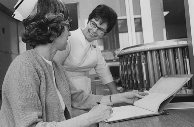 black and white photo of two nurses laughing with each other