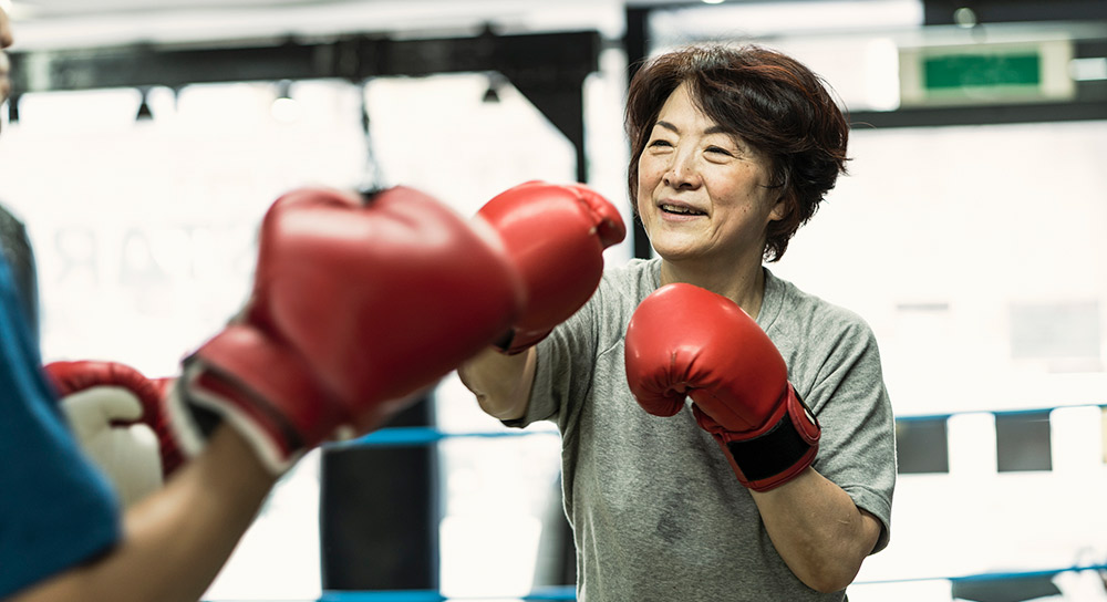 A woman holds up her hands in boxing gloves