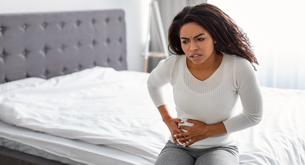 A woman holds her side in pain