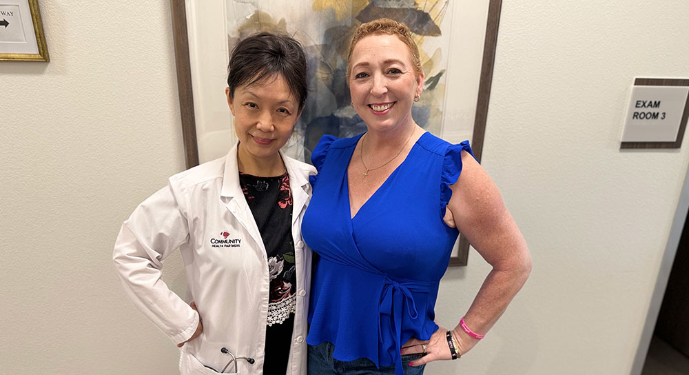 Dr. Li Lisa Ge and patient April Moreno smile near a patient exam room door