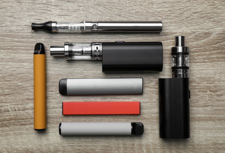 collection of vape pens laying on a table