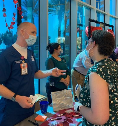 a male nursing representative from Community chats with a female nursing student at a booth during the Community career fair