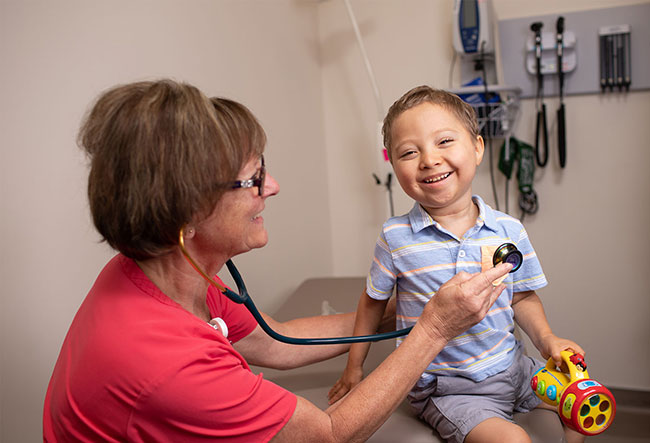 doctor holding stethoscope on smiling child
