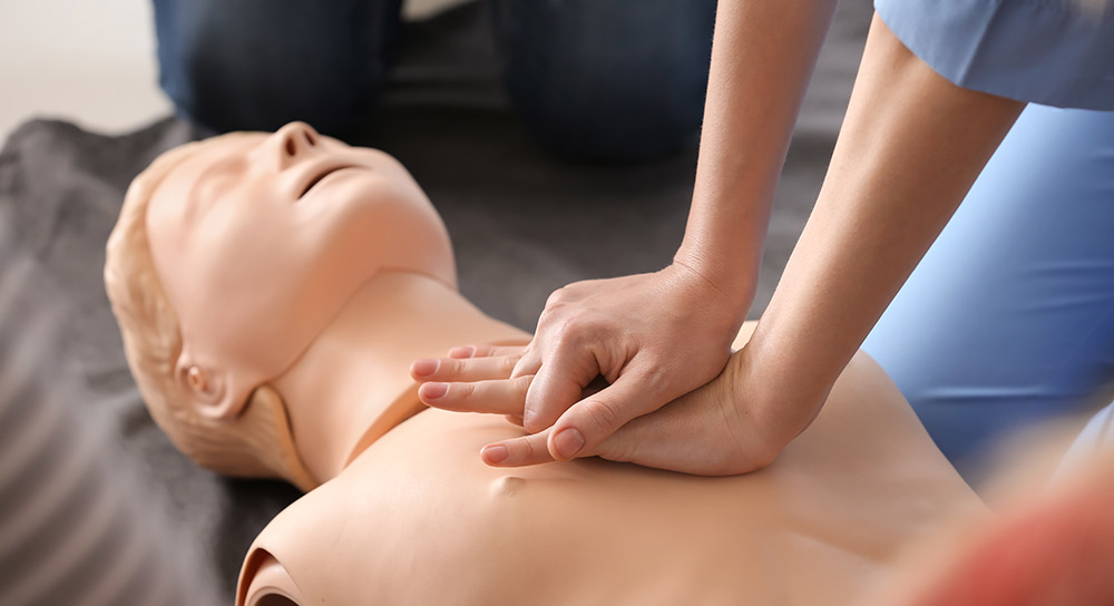 Hands press on a CPR dummy