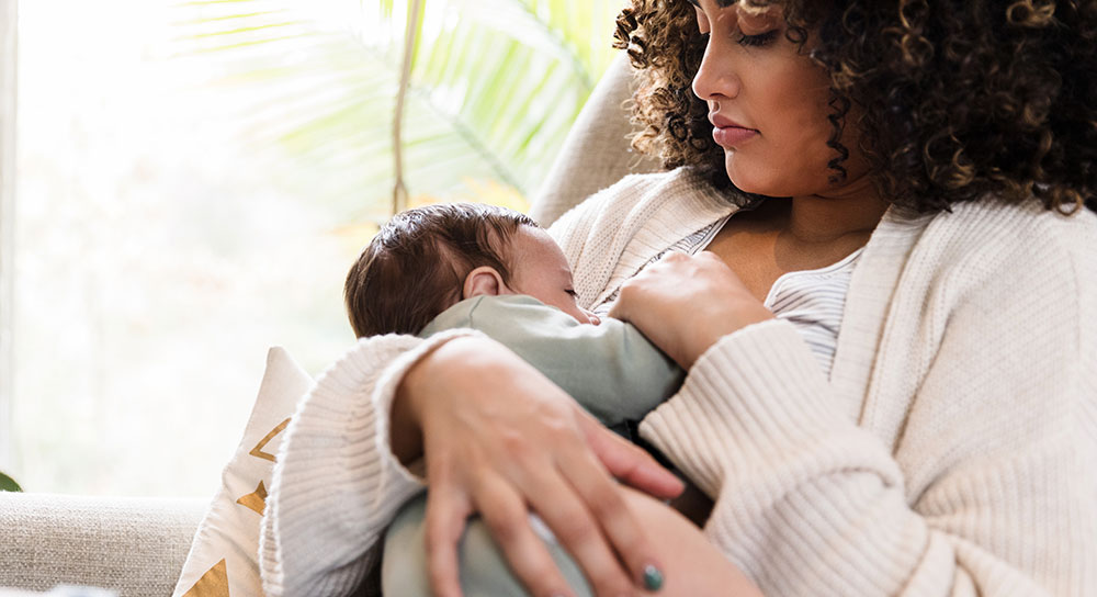 A young mom breastfeeds her newborn