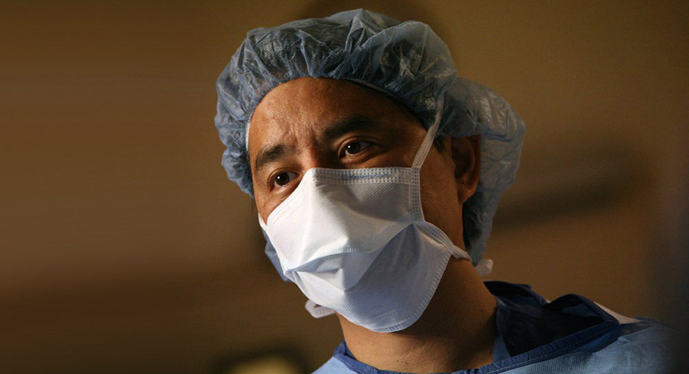 Dr. Higa masked and gowned up