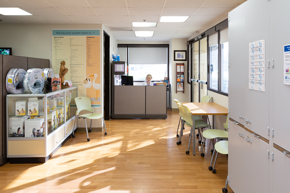 1800x1200_Mothers-Resource-Center Interior of the Mother's Resource Center showing a reception desk, informational posters on the wall, and breastfeeding products in a glass case.