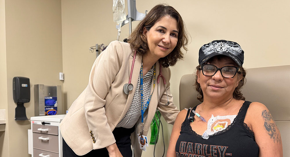 Dr. Abdulhaq stands close to patient Christine Quintero, who is undergoing treatment in a hospital bed