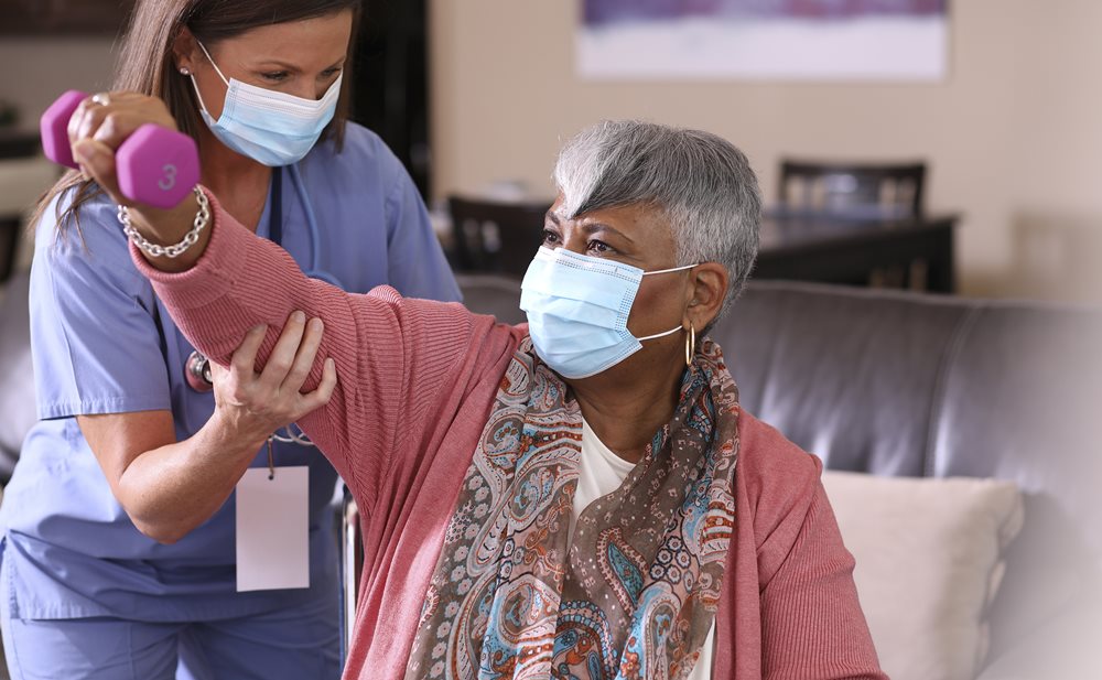 Neuro-Rehab Therapist helps woman lift weight