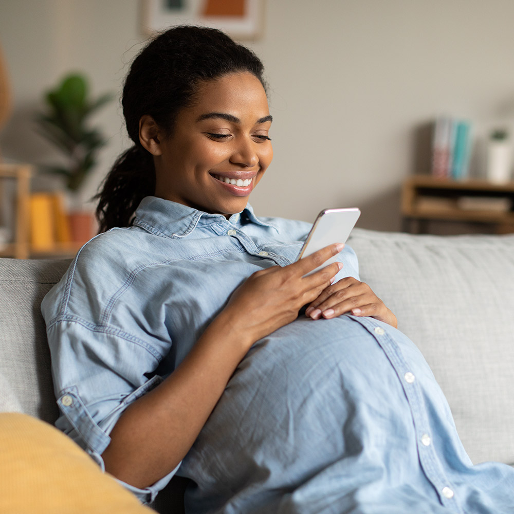 1000x1000_Pregnant-woman-looks-at-phone Pregnant woman looks at phone