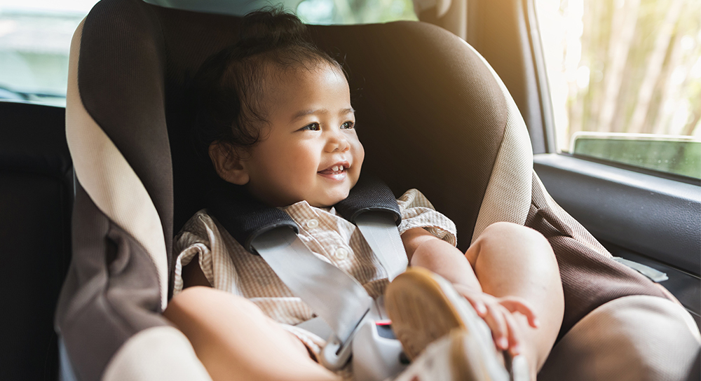 smiling child in a car seat