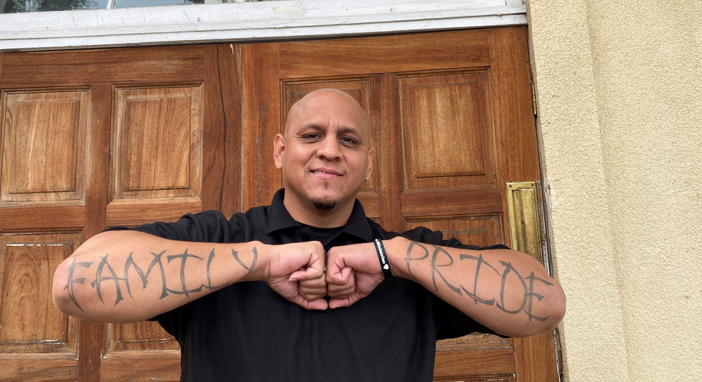 Armando Alvarez stands in front of the the door to a church